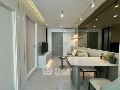 Modern living room with sleek design and open layout, featuring a cozy sofa and stylish dining area.