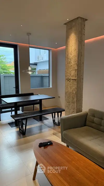 Modern living room with stylish furniture and exposed concrete pillar