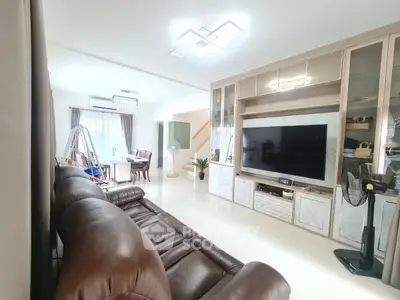 Spacious living room with modern decor and large TV, perfect for family gatherings.
