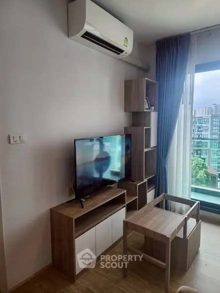 Modern living room with air conditioning and city view from large window.