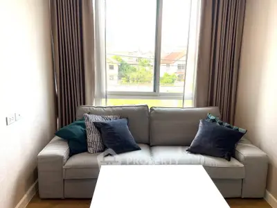 Cozy living room with a modern gray sofa and decorative pillows, perfect for relaxation.
