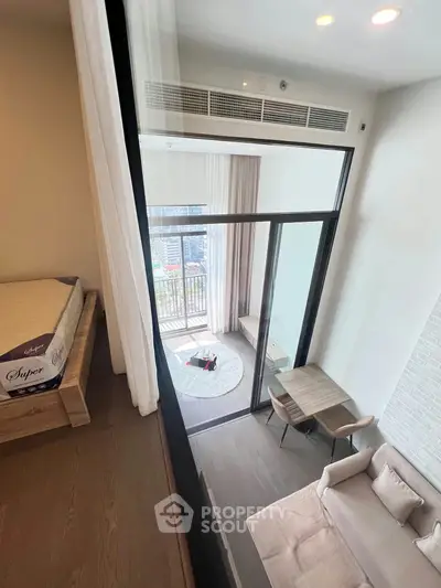 Modern loft apartment with mezzanine bedroom and stylish living area featuring floor-to-ceiling windows.