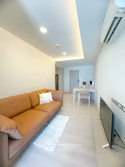 Modern living room with sleek design, featuring a cozy brown sofa and stylish decor.