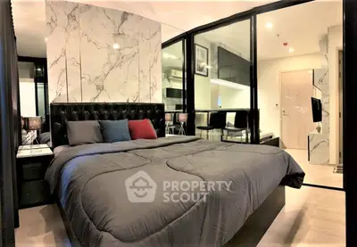 Luxurious modern bedroom with marble accent wall and glass partition in stylish apartment.