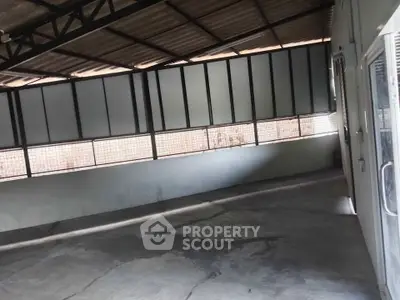 Spacious industrial-style interior with high ceilings and ample natural light, perfect for creative workspace.