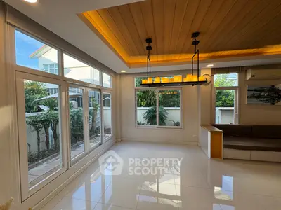 Spacious modern living room with large windows and stylish ceiling lighting