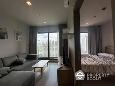 Modern condo with spacious living room and cozy bedroom, featuring large windows and city views.