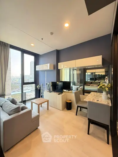 Modern living room with city view, stylish furniture, and natural light in a high-rise apartment.