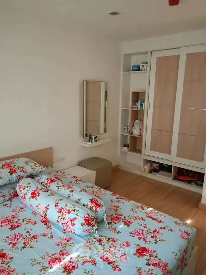 Cozy bedroom with floral bedding and built-in wardrobe, perfect for a serene retreat.