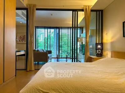 Luxurious bedroom with sliding glass doors opening to a spacious living area and lush garden view.