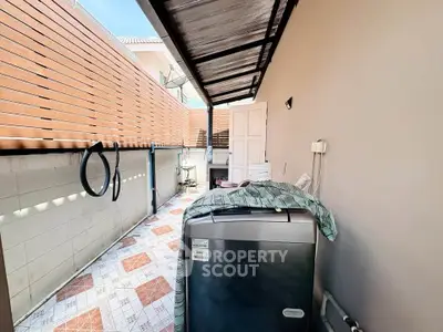 Charming outdoor laundry area with washing machine and tiled flooring, perfect for efficient home chores.