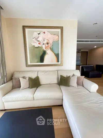 Elegant living room with stylish artwork and comfortable white sectional sofa.