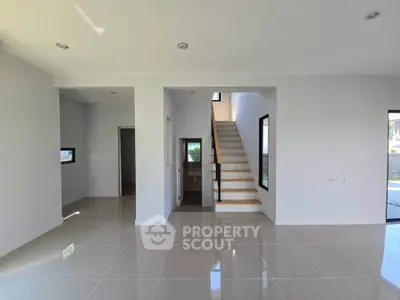 Spacious modern interior with sleek staircase and glossy tiled floors, perfect for contemporary living.
