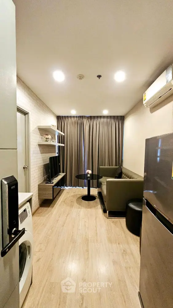 Modern living room with sleek furniture and appliances in a cozy apartment setting.