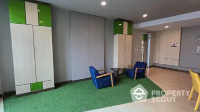 Spacious modern living room with vibrant blue armchairs, artificial grass area rug, and sleek white storage cabinets enhancing the contemporary vibe.