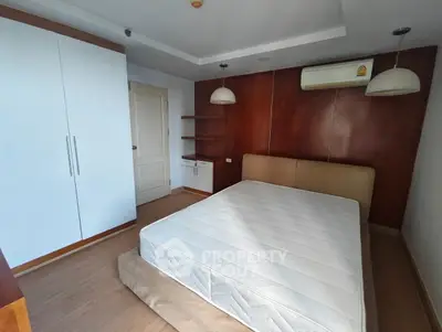 Spacious bedroom with modern design, featuring a large bed, built-in wardrobe, and stylish lighting.