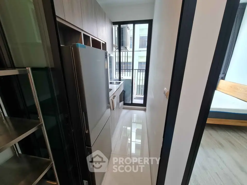 Modern kitchen with sleek appliances and balcony view in a stylish apartment