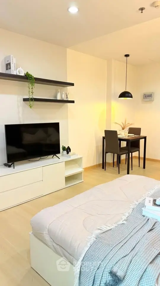 Modern living room with sleek TV setup and cozy dining area, perfect for urban living.