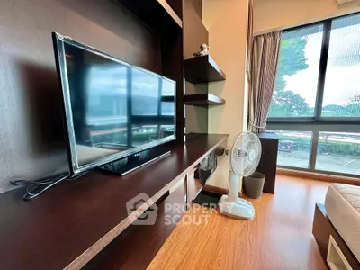 Modern living room with large window and sleek entertainment unit