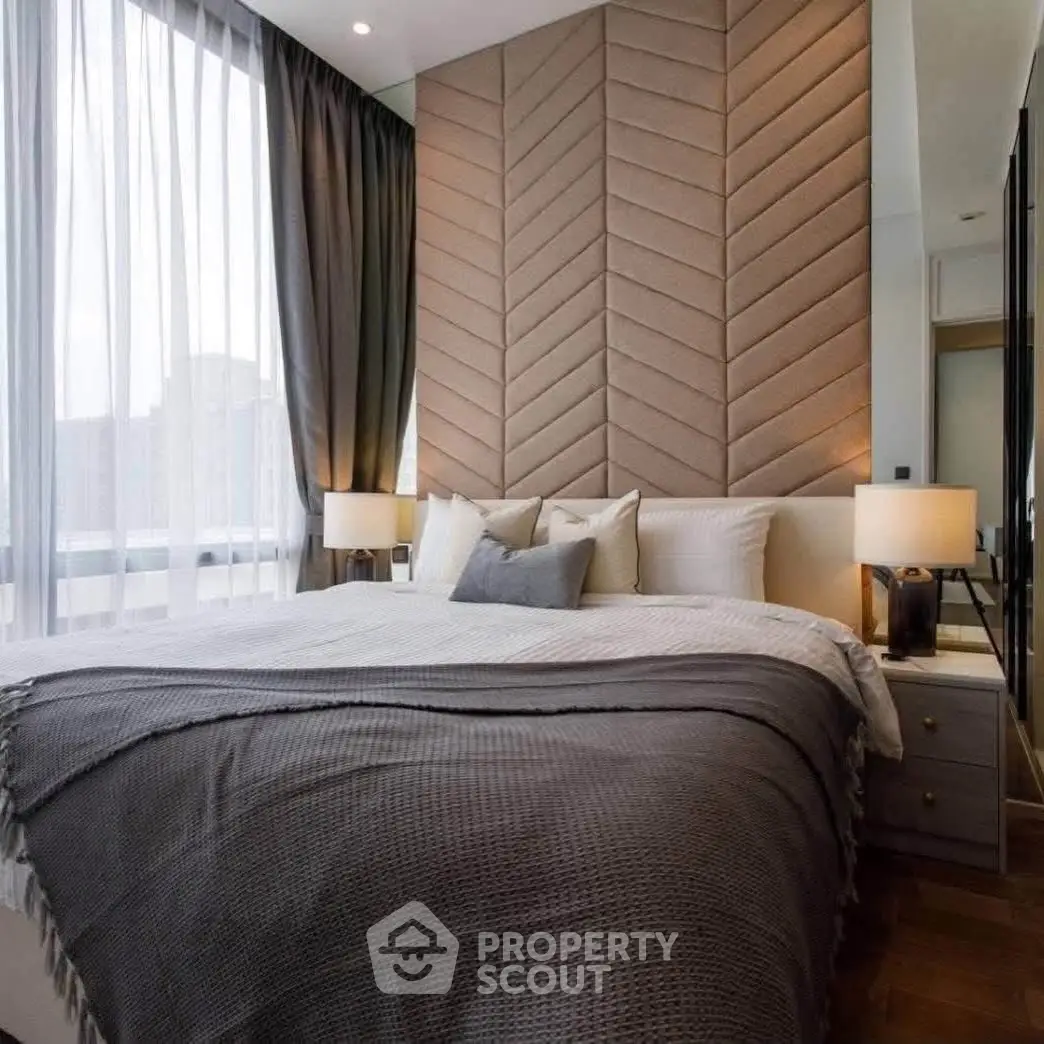 Luxurious bedroom with elegant decor and large windows offering natural light.