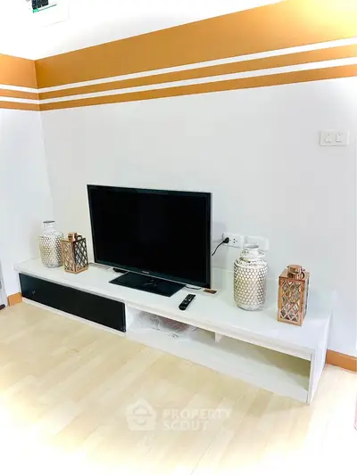 Modern living room with stylish TV setup and decorative accents on a sleek white console.