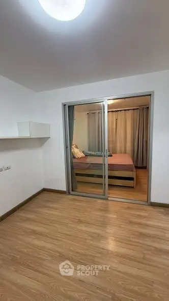 Spacious bedroom with sliding glass doors and wooden flooring, perfect for modern living.