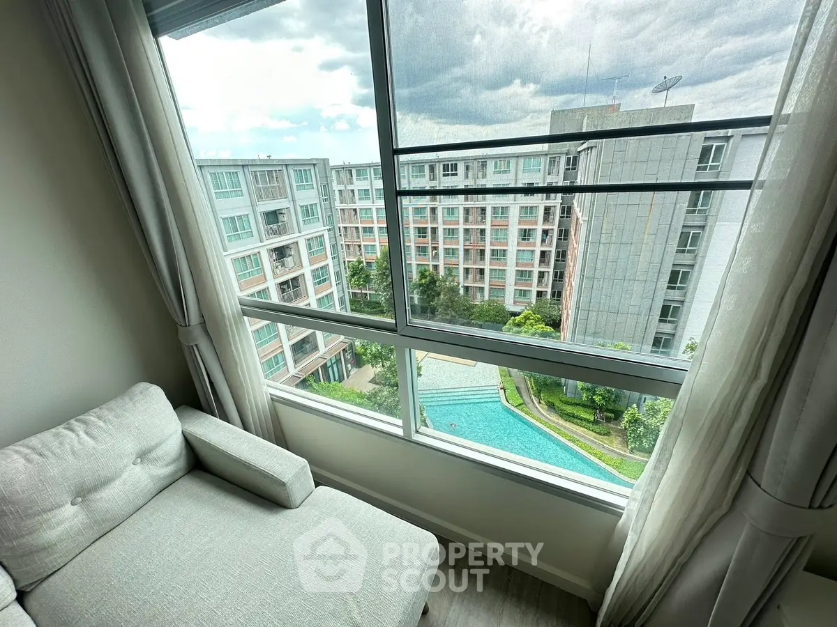 Modern apartment with pool view from cozy living room corner