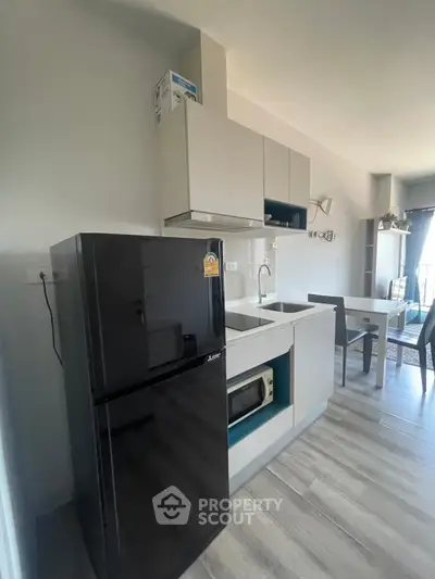 Modern kitchen with sleek black fridge and open layout design
