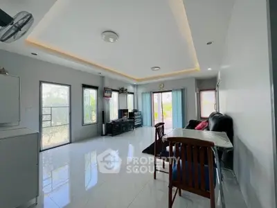 Spacious living room with modern decor and large windows offering natural light and garden views.