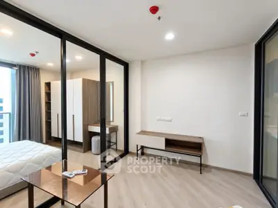 Modern bedroom with glass partition and minimalist furniture in a stylish apartment.