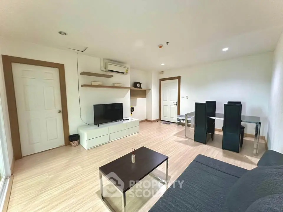 Spacious modern living room with dining area, featuring sleek furniture and bright lighting.