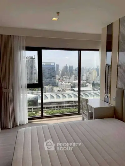 Luxurious bedroom with stunning city view from large window, featuring modern decor and cozy ambiance.
