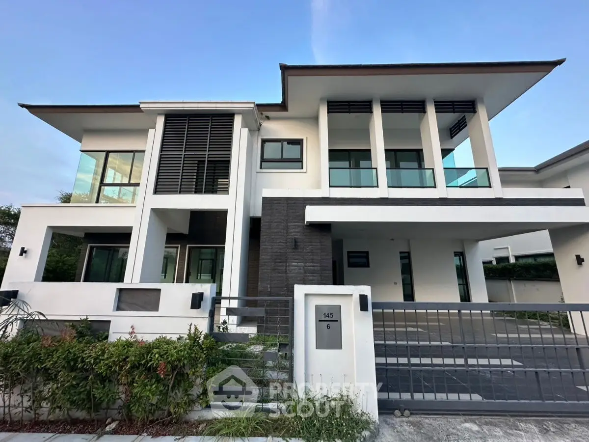 Modern two-story house with sleek design and spacious driveway in a serene neighborhood.