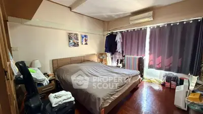 Cozy bedroom with large bed, air conditioning, and natural light from window.