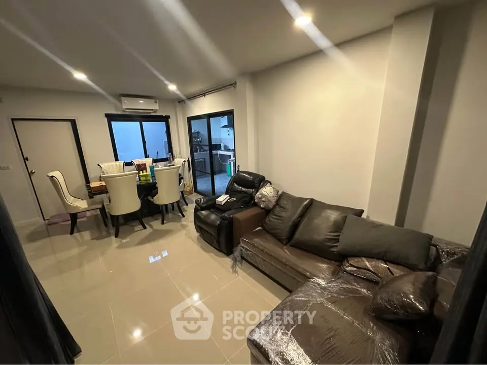 Spacious modern living room with elegant dining area and cozy seating, perfect for family gatherings.