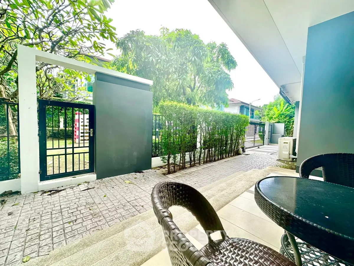 Charming garden patio with cozy seating and lush greenery, perfect for relaxation and outdoor enjoyment.