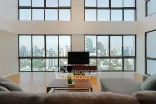 Spacious living room with panoramic city view and modern furnishings.
