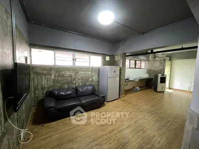 Spacious industrial-style living room with leather sofa and modern appliances.