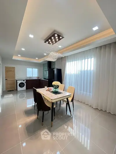 Modern dining area with elegant lighting and open kitchen layout
