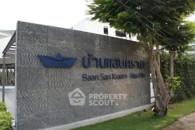 Entrance sign of Baan San Kraam Hua Hin with modern design and lush greenery.