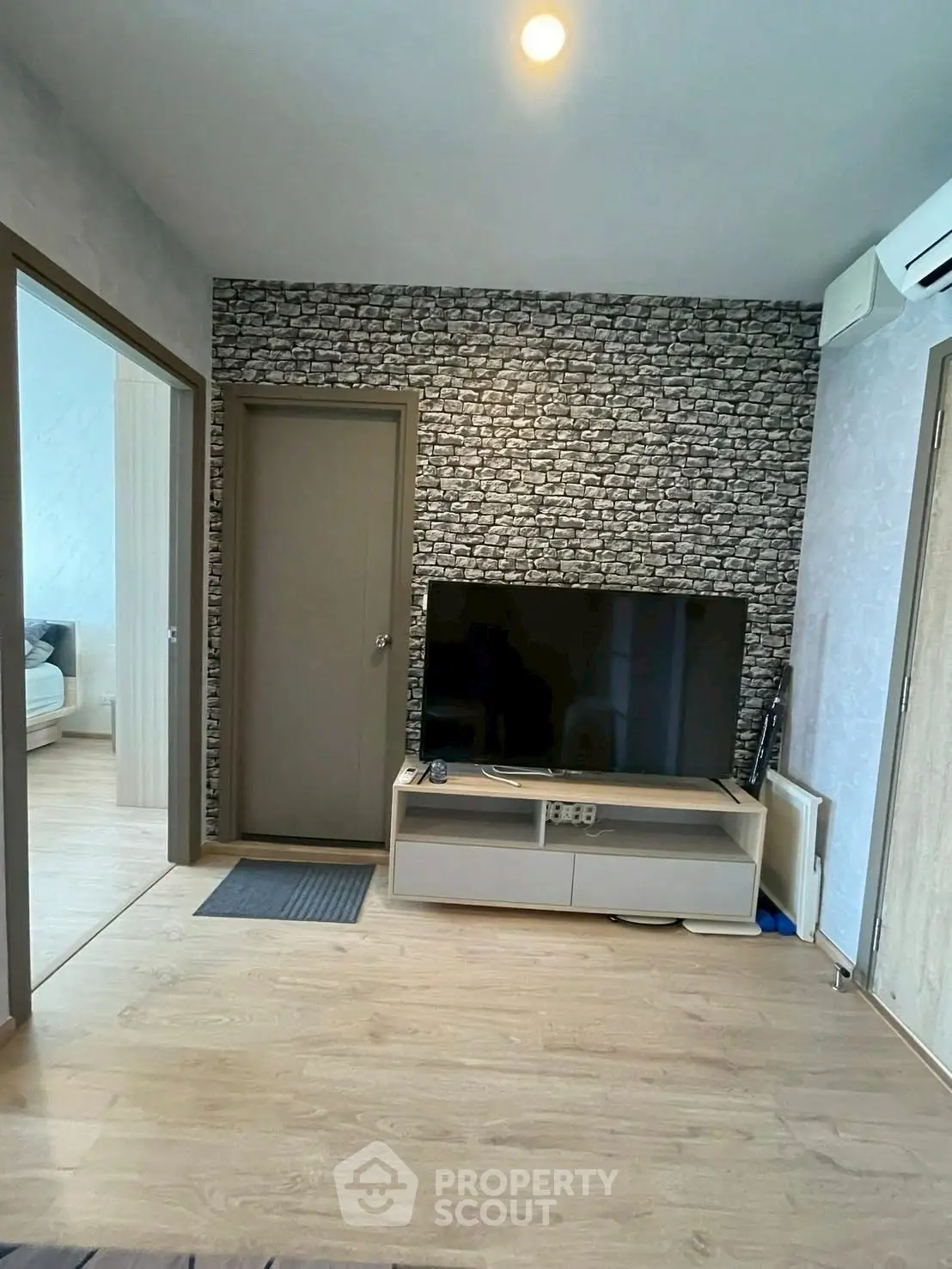 Modern living room with stylish stone accent wall and sleek TV setup