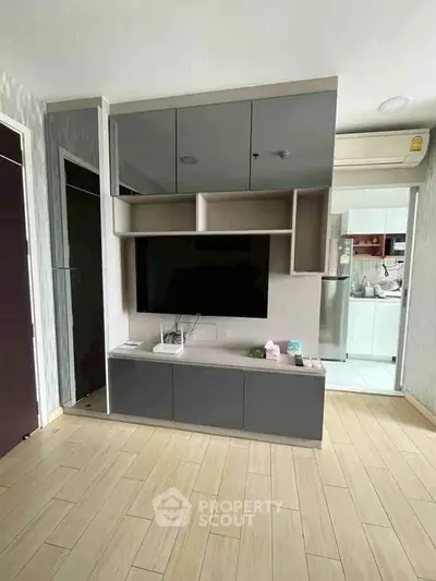 Modern living room with sleek TV unit and open kitchen view, perfect for contemporary urban living.