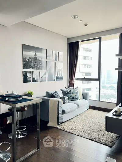 Modern living room with city view, stylish decor, and cozy seating area in a high-rise apartment.
