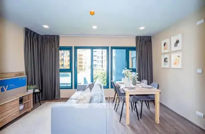 Modern living room with stylish decor and large windows offering natural light in a contemporary apartment.