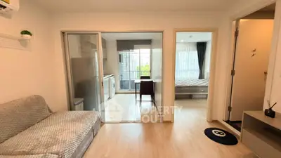 Modern apartment interior with open layout, featuring a cozy living room, kitchen, and bedroom with natural light.