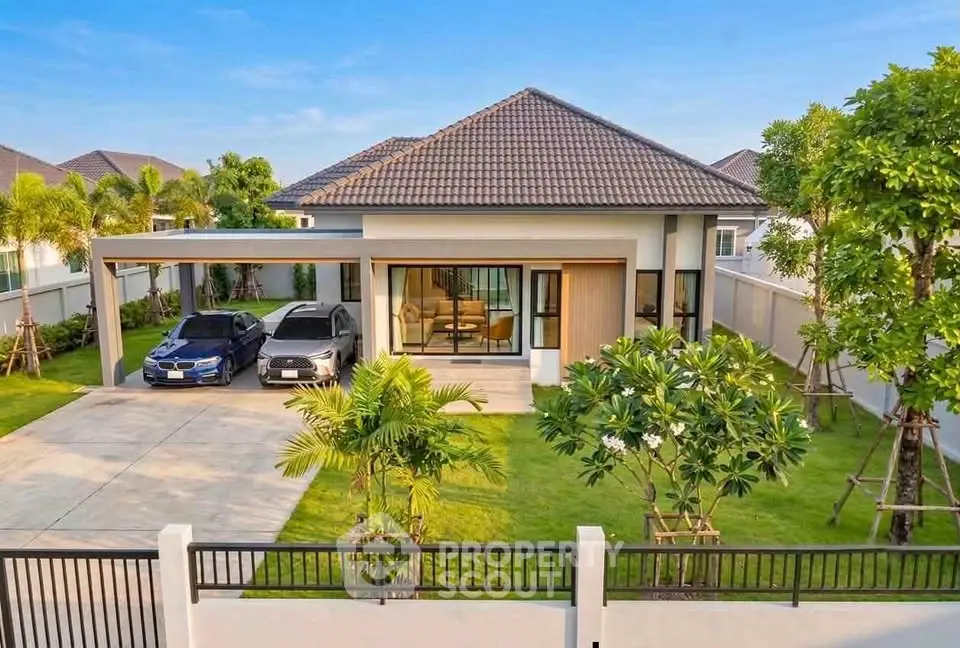 Modern single-story house with two-car driveway and lush green lawn
