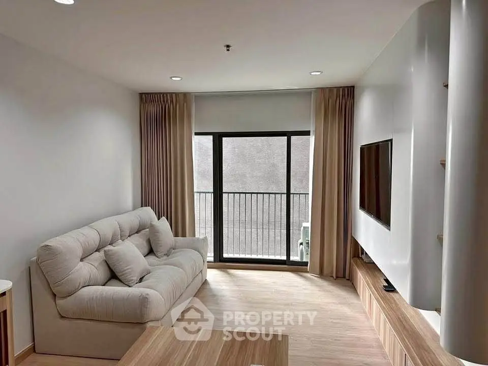 Modern living room with cozy sofa and large window in stylish apartment.