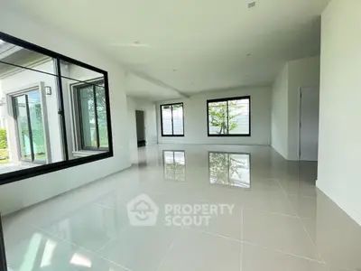 Spacious modern living room with large windows and glossy tile flooring