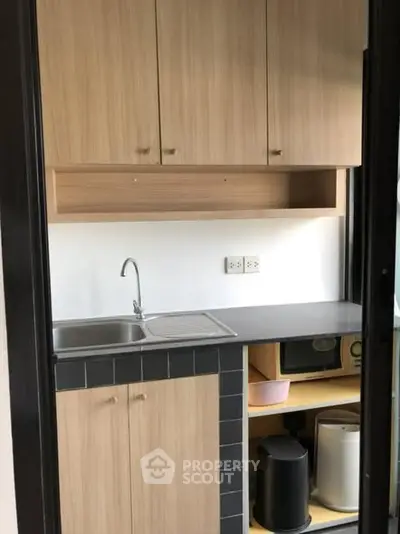 Compact kitchen with wooden cabinets and modern appliances