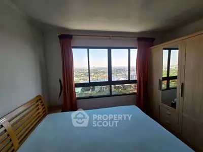 Spacious bedroom with stunning city view from large window, featuring modern wooden furniture.